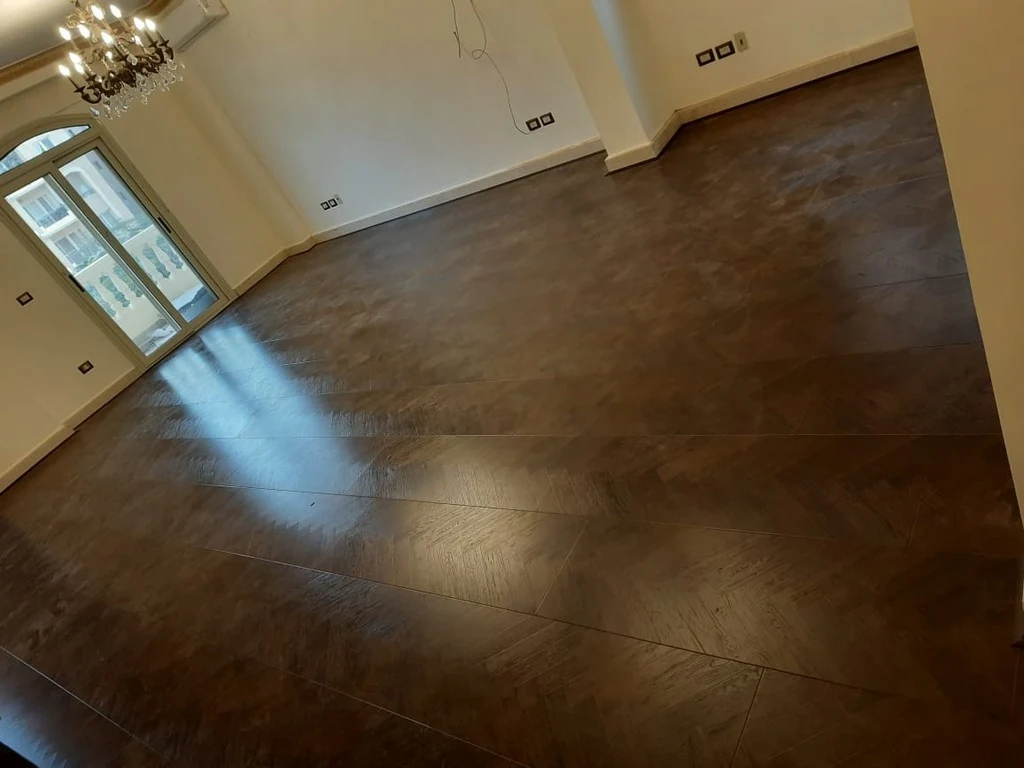 تنفيذ واقعي لأرضية خشب باركيه سبعة في ثمانية (Chevron) غامق فاخرة شركة Gold Flooring